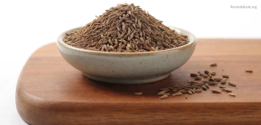 Curved brown caraway seeds in a ceramic bowl on a wooden board.