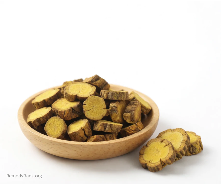 A wooden bowl of dried yellow-brown goldenseal root pieces sits beside a few whole root slices.