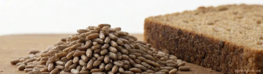 Whole rye grains beside a slice of dark rye bread.